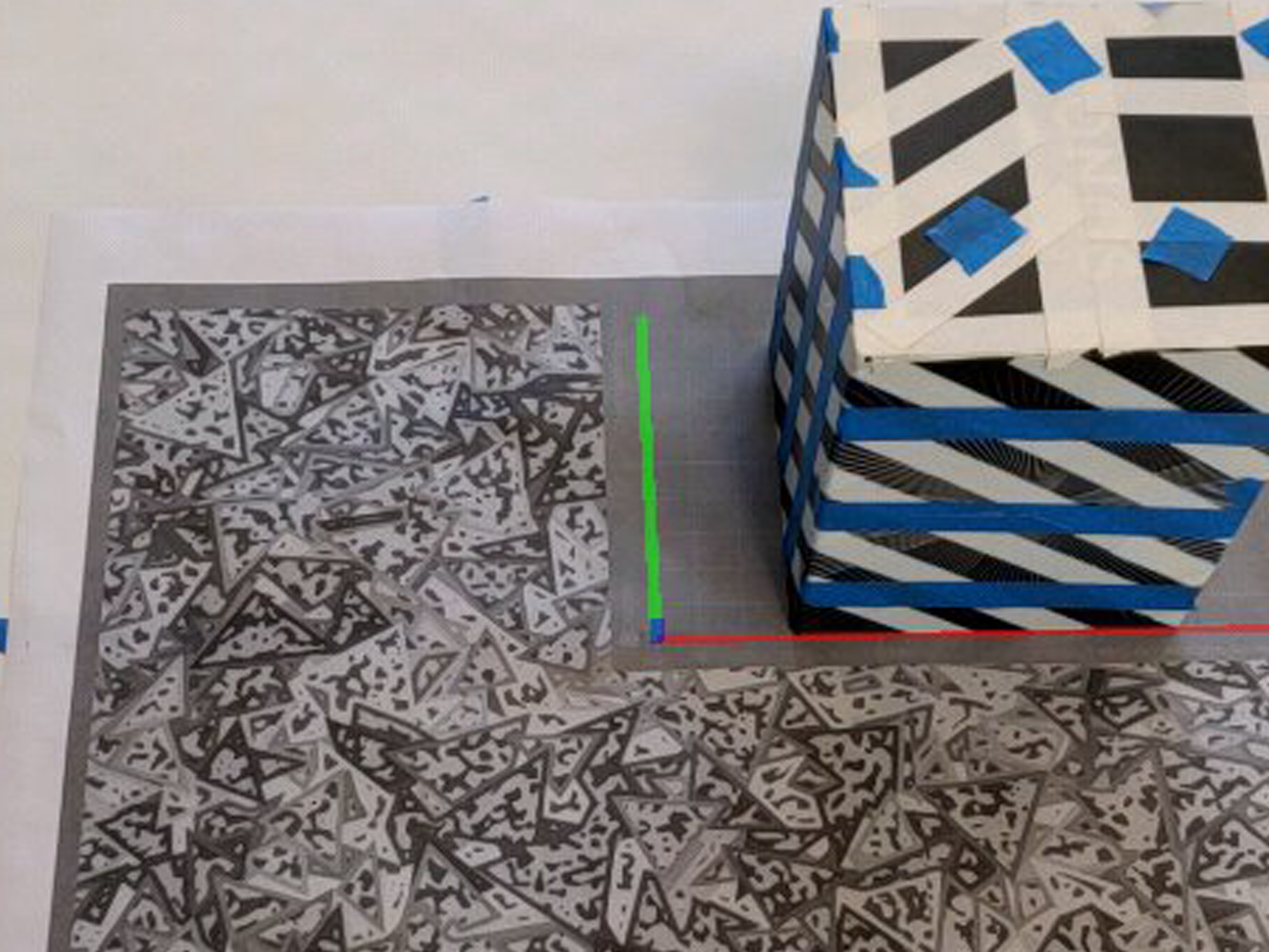 AR tracking test — striped cube on marker surface with axis overlay
